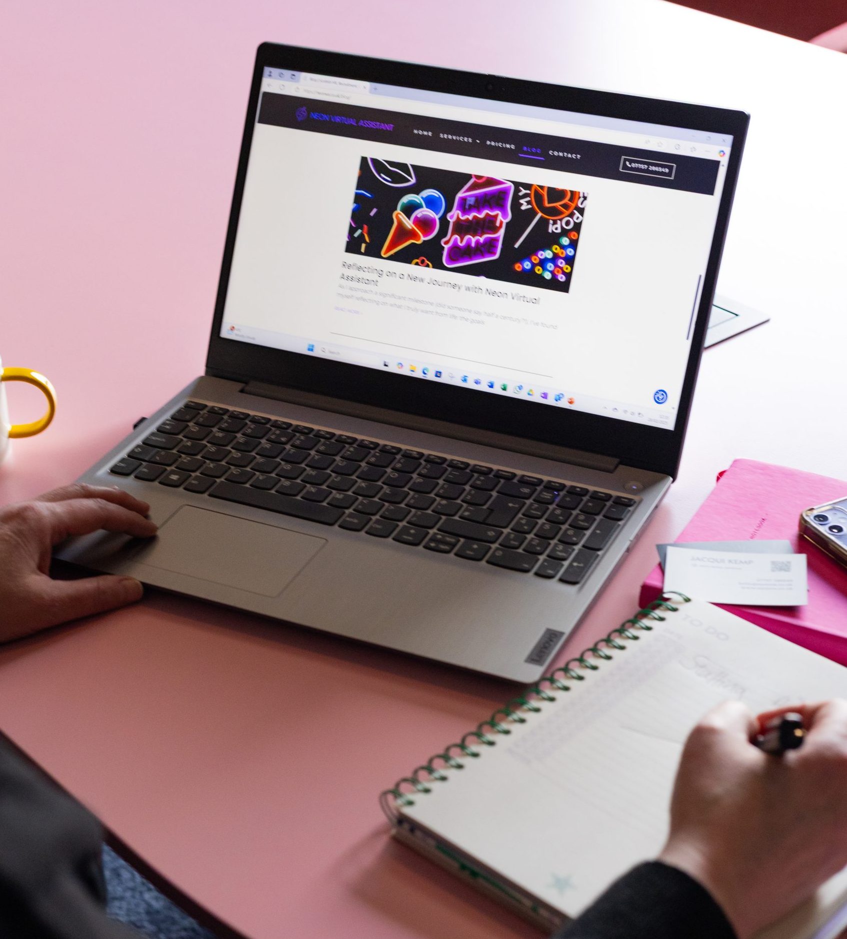 Laptop open with Blog page on screen, notepad next to laptop being written on