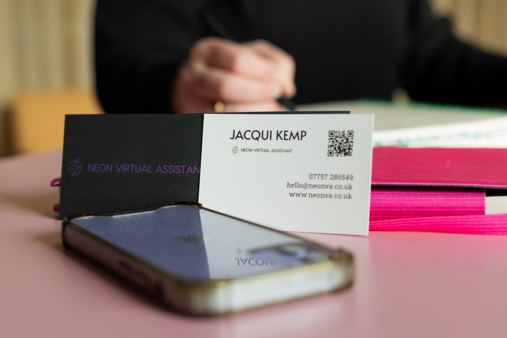 Close up of Jacqui Kemp Business card next to a mobile phone